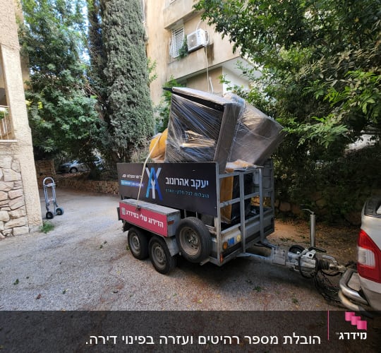עגלה עם רהיטים עטופים, שם יעקב אהרונוב על השלט